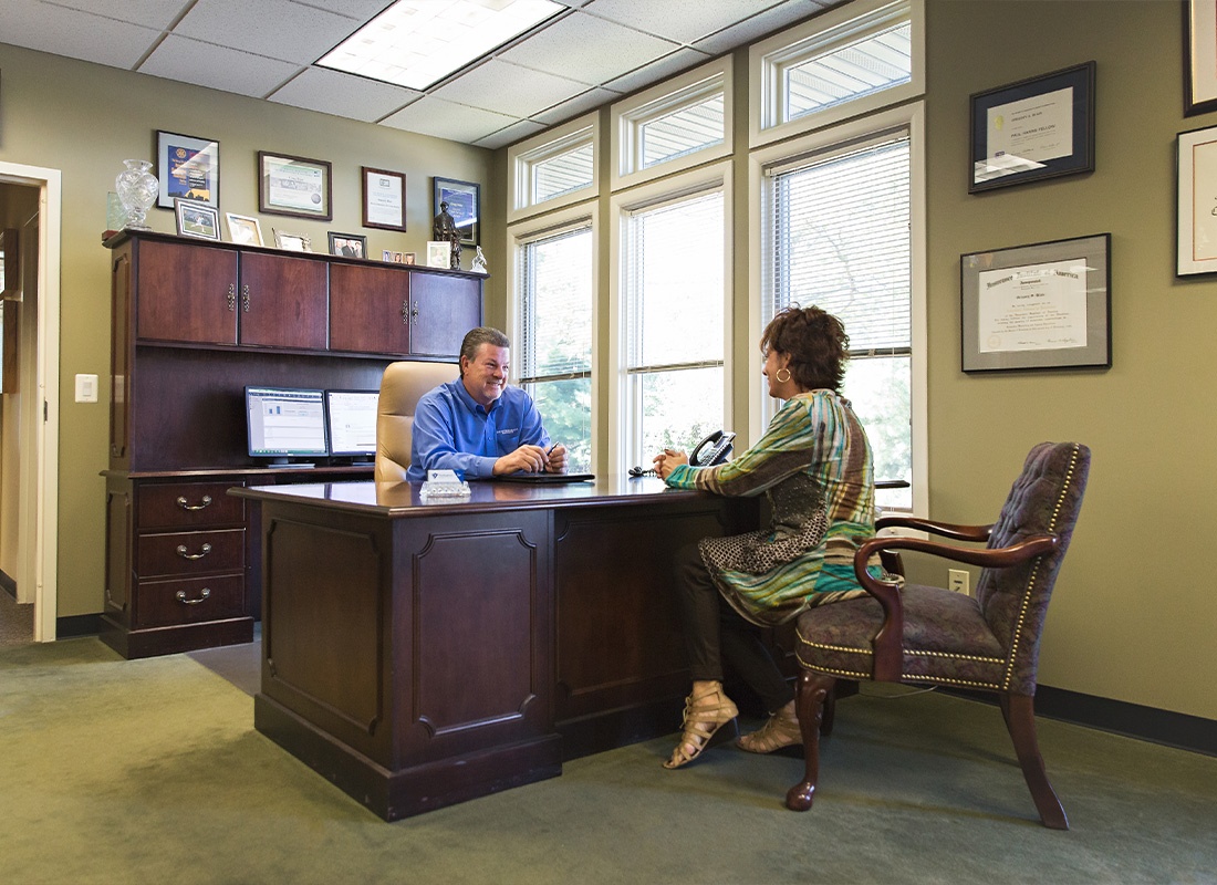 Service Center - Nottingham Insurance Employee Meeting With a Customer at a Wooden Desk